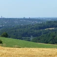Weitblick auf das Ruhrgebiet Blick auf das Ruhrgebiet mit ausgedehnten Wäldern, Feldern und eine sich am Horizont erstreckende Skyline.