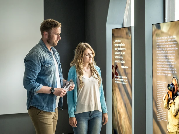 Couple reads explanations about the photographer Anja Niedringhaus in the museum