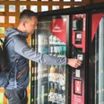 Proviantomat in Rathen Ein Mann mit Rucksack bedient einen Getränke- und Snackautomaten, der mit Flaschen und verpackten Lebensmitteln gefüllt ist.A man with a rucksack operates a drinks and snack vending machine filled with bottles and packaged food.Muž s batohem obsluhuje automat na nápoje a občerstvení plný lahví a balených potravin.Mężczyzna z plecakiem obsługuje automat z napojami i przekąskami wypełniony butelkami i pakowanym jedzeniem.Een man met een rugzak bedient een drank- en snackautomaat vol flesjes en verpakte etenswaren.Un uomo con uno zaino gestisce un distributore automatico di bevande e snack pieno di bottiglie e cibo confezionato.