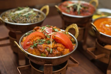 Pixabay indian-food.jpg Eine farbenfrohe indische Mahlzeit mit frischen Tomatenscheiben, serviert in einer Kupferschale.