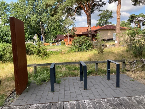 Charging station for e-bikes at the Mardorf Nature Park House, surrounded by nature and with an adjacent building.