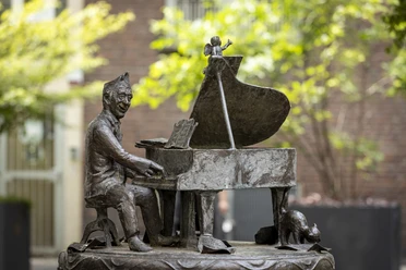 Jupp Schmitz memorial Sculpture of Jupp Schmitz at the piano, surrounded by trees.
