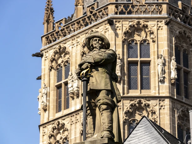 Jan von Werth Monument and City Hall Jan von Werth monument in Cologne in front of the impressive façade of a historic building. The statue of the horseman is richly detailed and stands out against the background.