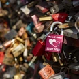 Liebesschlösser Bunte Vorhängeschlösser mit Gravuren zieren ein Gitter, symbolisieren Liebe und Verbundenheit.Colorful padlocks with engravings adorn a lattice, symbolizing love and solidarity.