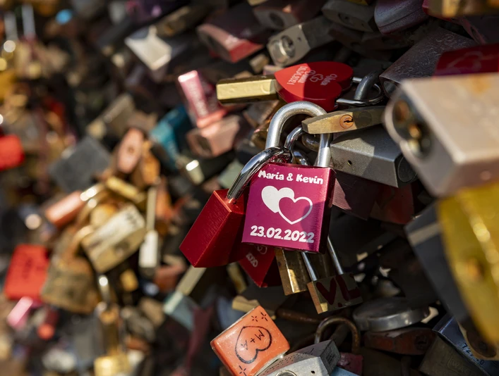 Love locks Bunte Vorhängeschlösser mit Gravuren zieren ein Gitter, symbolisieren Liebe und Verbundenheit.Colorful padlocks with engravings adorn a lattice, symbolizing love and solidarity.