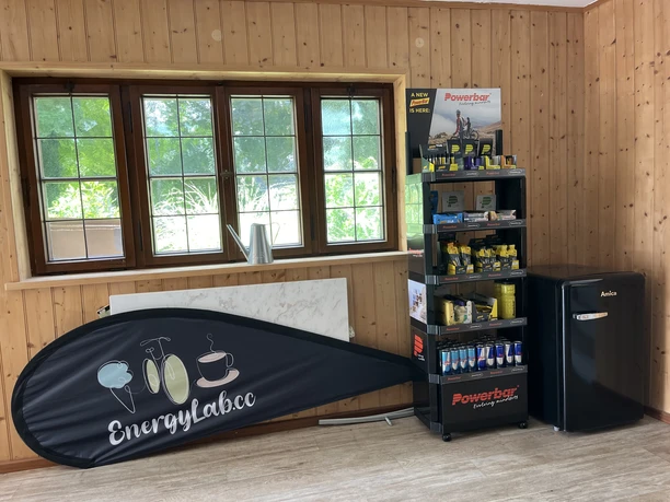 Energy Lab Farchant - Innenbereich mit Vorrat an Powerriegeln zum Verkauf Innenbereich mit einem Regal voller Powerriegel und Fitnessdrinks