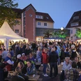 Vlothoer Weinfest 2023 Menschen genießen das Vlothoer Weinfest 2023 im Freien mit Lichterketten und Verkaufsständen.