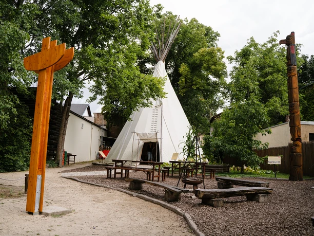 Außenaufnahme des Karl-May-Museum mit Garten.jpg Karl-May-Museum mit Tipi und Totempfahl im Garten, umgeben von Bäumen.