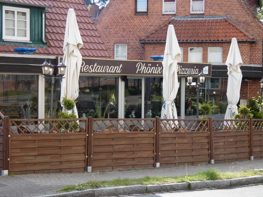 Restaurant Phönix_Silvana Dust_20230509.JPG Blick auf Außenplätze mit Tischen und zugeklappten Sonnenschirmen