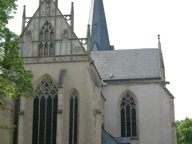 Seitliche Ansicht der Marienkirche Lippstadt, mit gotischen Fenstern und einem hohen Kirchturm.
