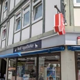 Ein Eckhaus mit hellem Fachwerk, im Erdgeschoss die Wolf Apotheke