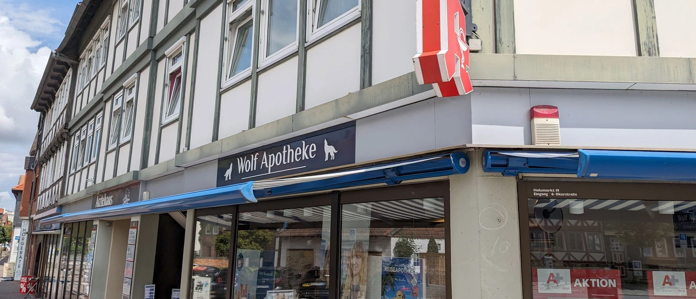 Ein Eckhaus mit hellem Fachwerk, im Erdgeschoss die Wolf Apotheke