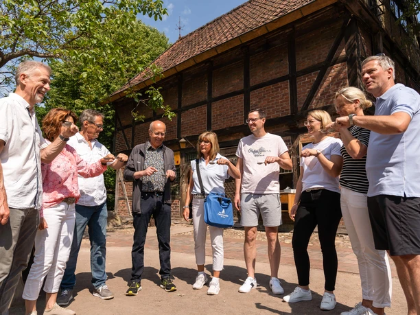gruppenangebot_anfaenger.jpg Eine Gruppe von Menschen steht im Kreis und fokussiert eine gemeinsame Aktivität im Freien.