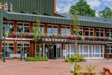Das Bild zeigt das Rathaus von Sottrum mit roter Backsteinfassade und blühendem Blumenschmuck.