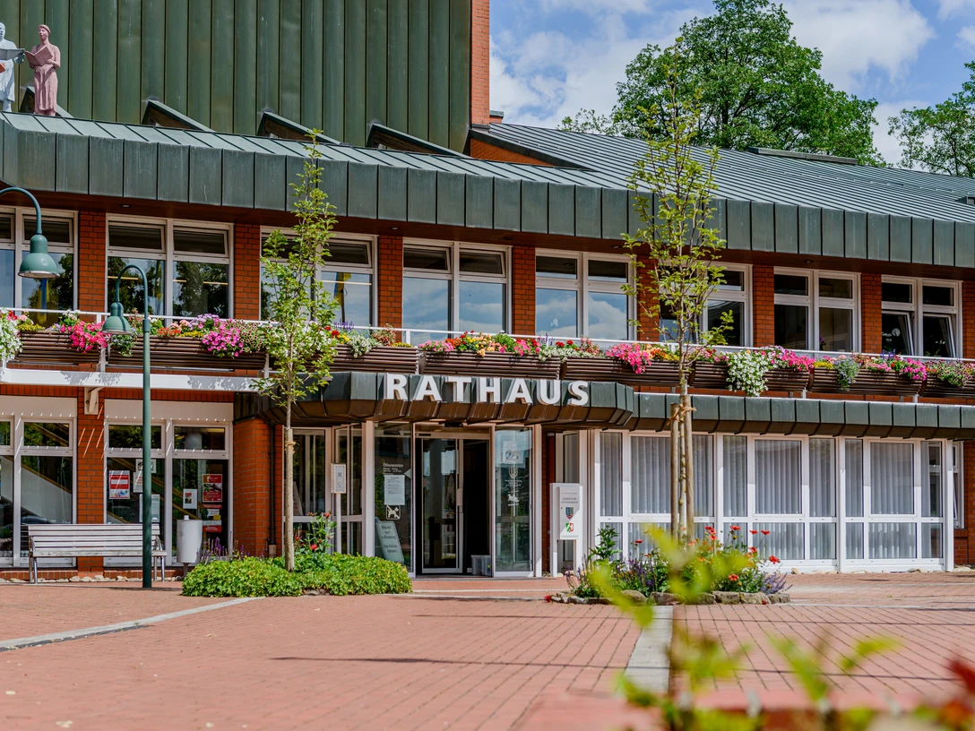 Rathaus Gemeinde Steinhagen (C) pro Wirtschaft GT, Mario Wallenfang.jpeg Das Bild zeigt das Rathaus von Sottrum mit roter Backsteinfassade und blühendem Blumenschmuck.