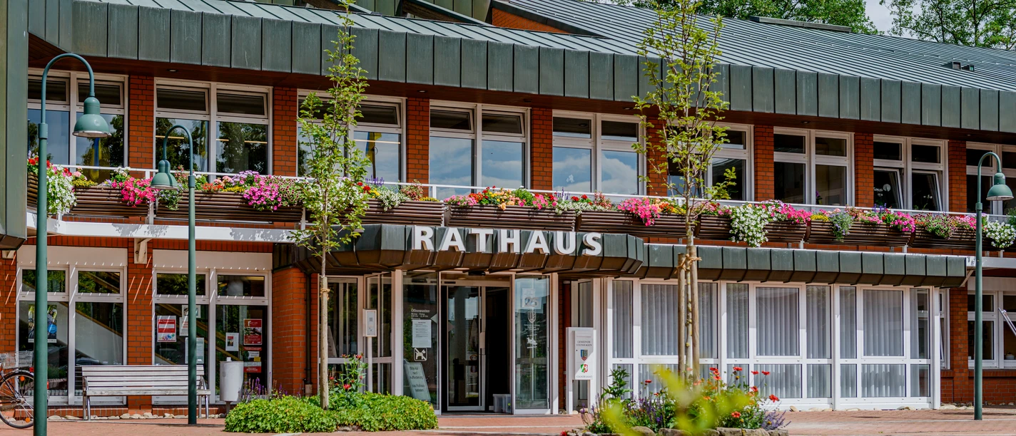 Rathaus Gemeinde Steinhagen (C) pro Wirtschaft GT, Mario Wallenfang.jpeg Das Bild zeigt das Rathaus von Sottrum mit roter Backsteinfassade und blühendem Blumenschmuck.