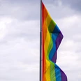 Cologne Pride Eine bunte Regenbogenflagge weht im Wind vor bewölktem Himmel.A colorful rainbow flag flies in the wind against a cloudy sky.