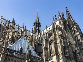 Cologne Cathedral Kölner Dom mit beeindruckenden gotischen Türmen und filigraner Architektur unter strahlend blauem Himmel.Cologne Cathedral with its impressive Gothic towers and intricate architecture under a bright blue sky.