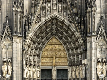 Kölner Dom Detailreiche gotische Fassade des Kölner Doms mit kunstvoll verzierten Statuen und steinerner Ornamente.Detailed Gothic façade of Cologne Cathedral with elaborately decorated statues and stone ornaments.