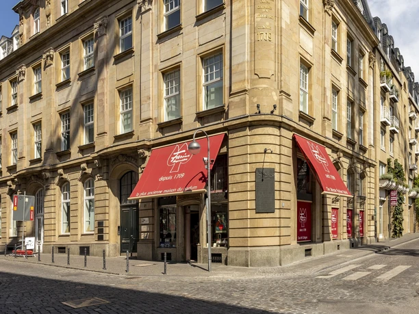Farina-Haus in der Kölner Altstadt Das Bild zeigt die elegante Fassade des Duftmuseums Farina in Köln unter einem strahlend blauen Himmel.