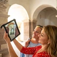 Female couple looking at the former ornate decorations in St. John's Choir on a tablet