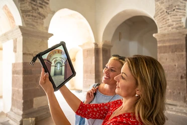 Hoexter-Augmented Reality in Johanneschor-Stadt Hoexter-D. Ketz-2023-459.jpg weibliches Pärchen betrachtet auf Tablet die früheren kunstvollen Verzierungen im Johanneschor