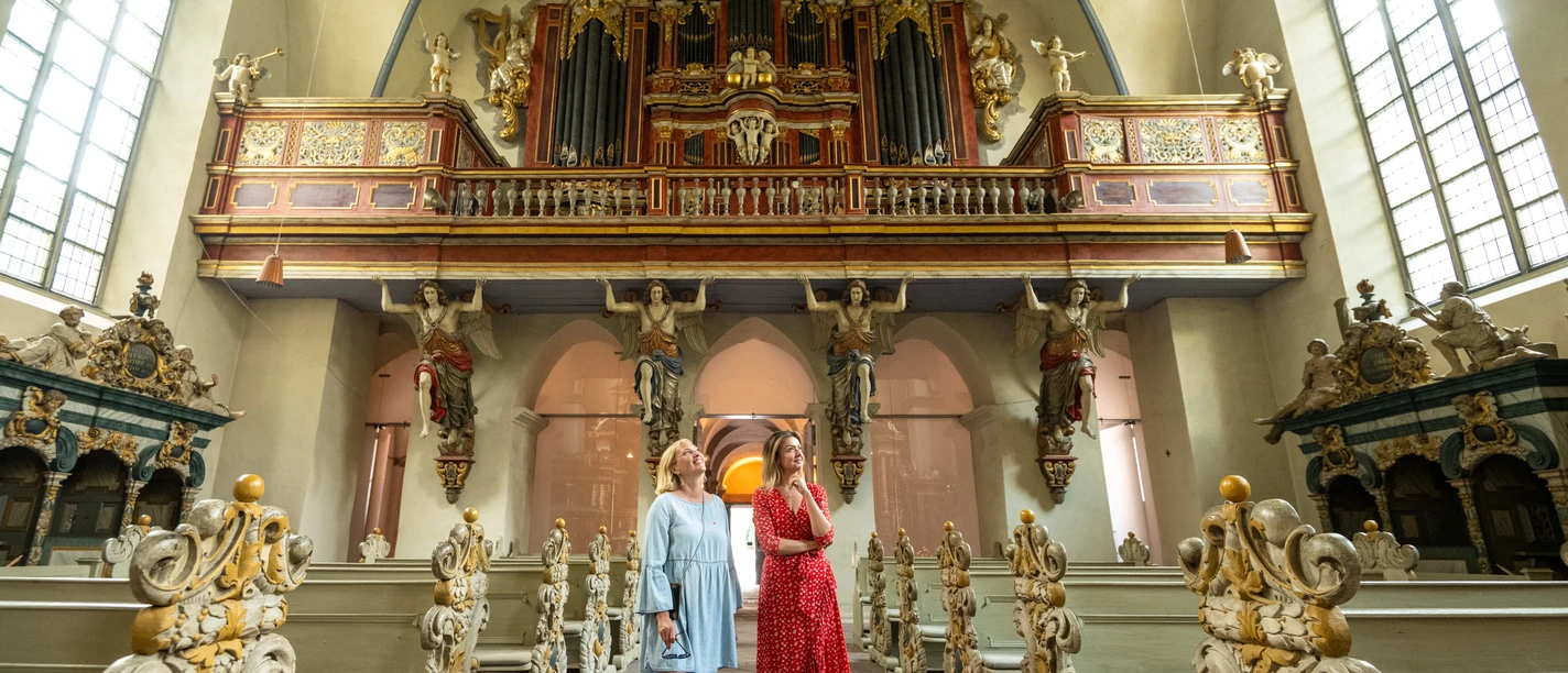 Zwei Frau besichtigen prächtige Barockkirche in Corvey