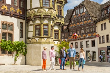 Hoexter-Stadtfuehrung-Stadt Hoexter-D. Ketz-2023-121.jpg Stadtführer erklärt Gästen die Geschichte vor historischen Gebäuden in Höxter