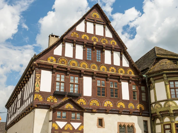 Stadtführer erklärt Gästen die Geschichte vor historischen Gebäuden in HöxterCity guide explains history to guests in front of historic buildings in Höxter