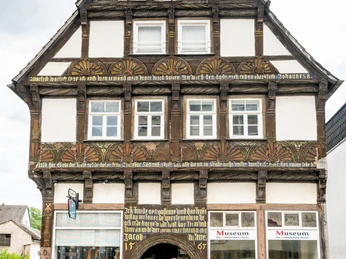 Hoexter-Museum im Huetteschen Haus-Stadt Hoexter-D. Ketz-2023-133.jpg Ein Pärchen verlässt das Museum im Hütteschen Haus durch einen reich verzierten Torbogen.A couple leaves the museum in the Hüttesches Haus through an ornate archway.