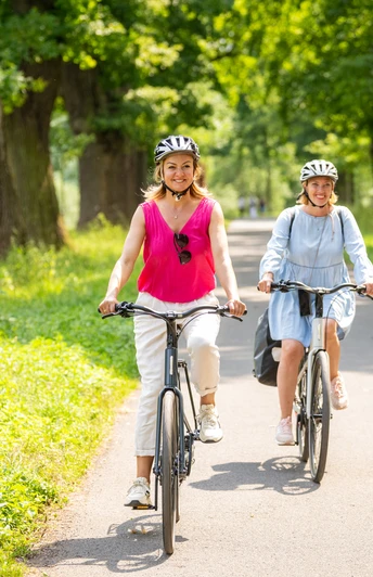 Hoexter-Landesgartenschaugelände Weserradweg-Stadt Hoexter-D. Ketz-2023-423.jpg Zwei Frauen genießen eine Radtour durch eine schöne, dicht bewachsene Eichenallee