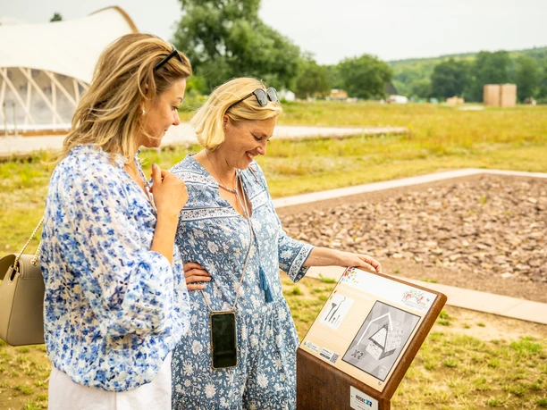 Zwei Frauen vor Informationstafel in Archäologiepark