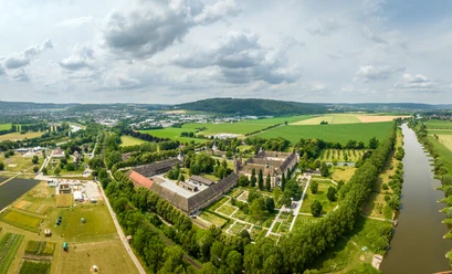 Hoexter-Kloster Corvey-Stadt Hoexter-D. Ketz-2023-442.jpg Luftaufnahme des Klosters Corvey in Höxter, umgeben von Grünflächen und einem Fluss.