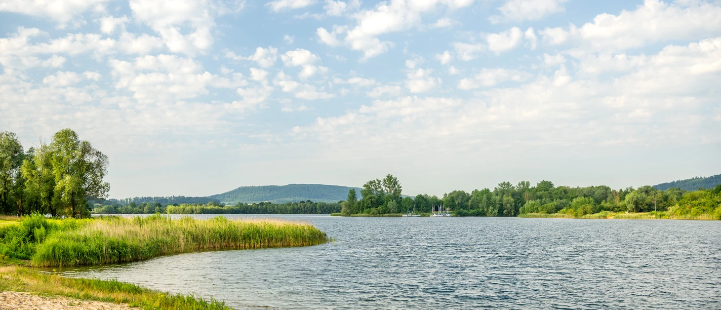 Badesee mit grünen Uferrändern auf beiden Seiten