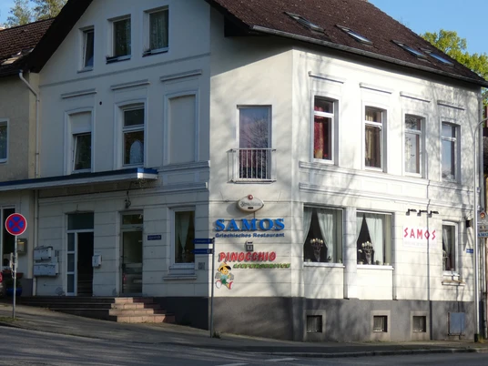Griechisches Restaurant Samos_Silvana Dust_20230510 (2)1980X1080.jpg Weißes Eckgebäude mit der Aufschrift „Samos“