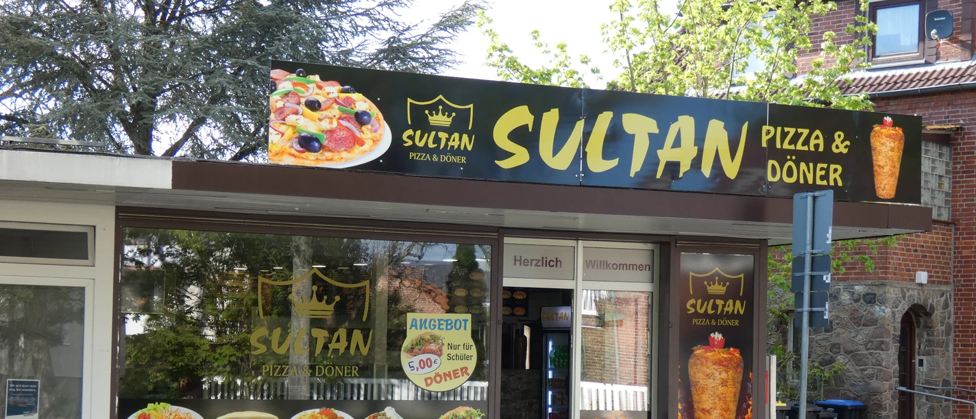 Sultan Pizza&Döner_Silvana Dust_20230509.JPG Außenansicht eines Gebäudes mit Aufklebern, die die angebotenen Speisen zeigen