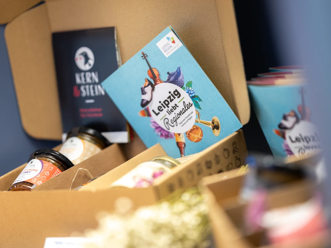 Office de tourisme de Leipzig – Produits régionaux originaires de Leipzig Foto einer Geschenkekiste der Leipziger Manufaktur "Kern und Stein", die im Souvenirbereich der Tourist-Information Leipzig steht, Regionale ProdukteFotografia skrzyni prezentów lipskiej manufaktury „Kern und Stein”, która stoi w strefie pamiątek Informacji Turystycznej w Lipsku, produkty regionalnePhoto of a gift box containing hand-made products from the Leipzig artisan company "Kern und Stein" in the souvenir department at Leipzig Tourist Information Office, local products.Photo d'un coffret cadeau de l’atelier « Kern und Stein » de Leipzig, dans la boutique de souvenirs de l'office de tourisme de Leipzig, Produits régionauxFotografie dárkové skříňky od lipské manufaktury „Kern und Stein", kterou najdete v koutku se suvenýry v lipském turistickém informačním centrum, regionální produktyFoto van een geschenkdoos van de Leipziger manufactuur "Kern und Stein", in de souvenirafdeling van het Toeristisch Informatiecentrum Leipzig, regionale productenFoto di una confezione regalo della manifattura di Lipsia "Kern und Stein", situata nell'area souvenir del Centro informazioni turistiche di Lipsia, prodotti regionali
