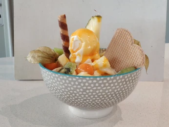 Degrassi Eiscafé Fruchtbecher Fruchtbecher mit Ananas, Kiwi und Physalis. Sahnekugel, Waffeln und Sirup runden den Genuss ab.