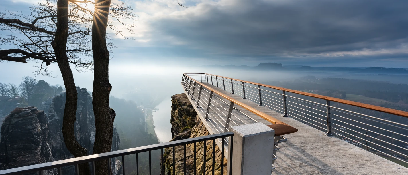 Aussichtsplattform Bastei Aussichtsplattform mit Blick über nebelverhangene Landschaft und steilen Felsformationen.