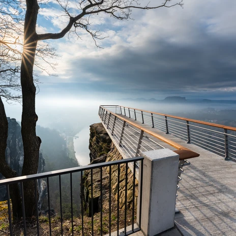 Aussichtsplattform Bastei Aussichtsplattform mit Blick über nebelverhangene Landschaft und steilen Felsformationen.