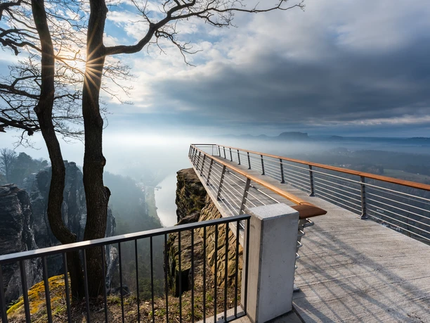 Aussichtsplattform Bastei Aussichtsplattform mit Blick über nebelverhangene Landschaft und steilen Felsformationen.