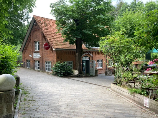 FarchauerMuehle_Aussenansicht_Restaurant_29062023_PetraRoemer.jpg Außenansicht eines Restaurants, umgeben von viel Grün