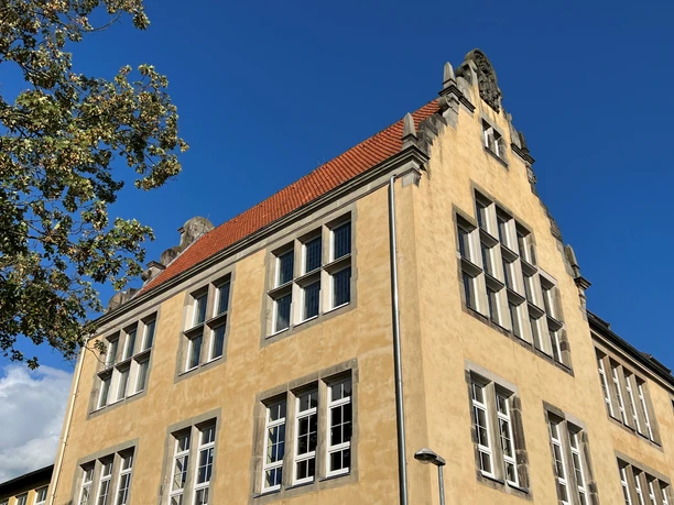 Die Albert Schweitzer-Schule beeindruckt mit ihrem spitz zulaufenden Giebelsaal und großflächigen Fenstern.