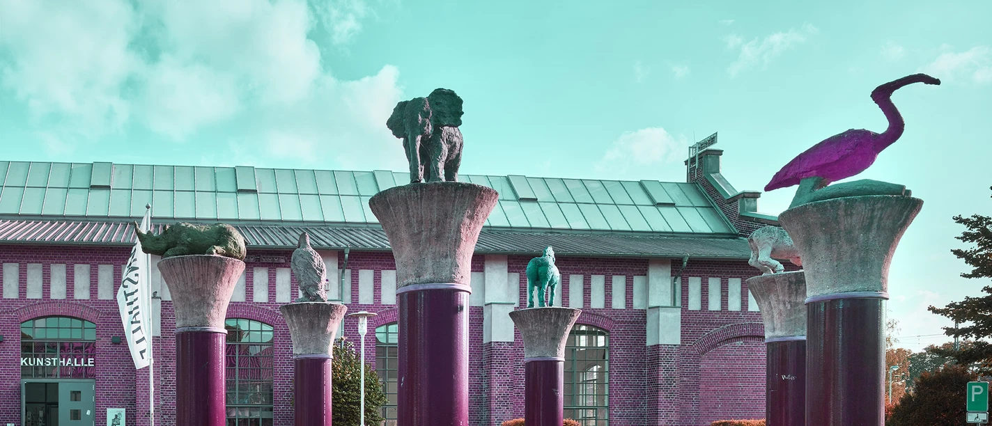 Bild Kunsthalle Lingen.jpg Ziegelbau mit Säulenanlage und Tierfiguren vor der Kunsthalle Lingen unter blauem Himmel