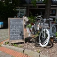 Café Fensterplatz im Herzen von Enger Kleines Café in Enger mit Fahrrad vor der Tür und Tafel mit hausgemachten Kuchenvarianten.