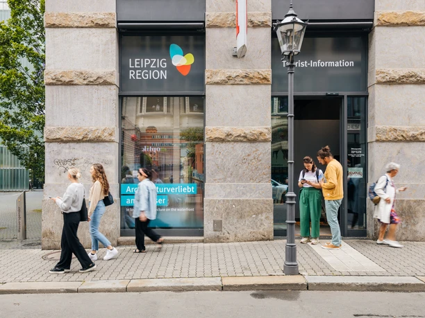Tourist-Information-Leipzig-Außen-Haupteingang-Service-Reise-Philipp-Kirschner-leipzig-travel.jpg Tourist-Information Leipzig, Haupteingang, Menschen gehen vorbei, moderne Glasfront.