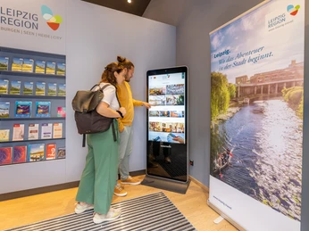 Tourist-Information-Leipzig-Infostele-Service-Digital-Reise-Philipp-Kirschner-leipzig-travel.jpg Zwei Personen nutzen eine digitale Infostele in einem Tourismusbüro in Leipzig.Two people use a digital information point in a tourist office in Leipzig.Dva lidé využívají digitální informační bod v turistické kanceláři v Lipsku.Dwie osoby korzystają z cyfrowego punktu informacyjnego w biurze turystycznym w Lipsku.Twee mensen gebruiken een digitaal informatiepunt in een toeristenbureau in Leipzig.Due persone utilizzano un punto informativo digitale in un ufficio turistico di Lipsia.