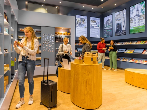 Tourist-Information-Leipzig-Regionale-Produkte-Überblick-Service-Souvenirs-Reise-Philipp-Kirschner-leipzig-travel.jpg Besucher in einem modernen Geschäft mit regionalen Produkten und Souvenirs.