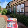 Hippolit Bücherei Broschüre vor dem Eingang des Fachwerkgebäudes der Hippolit-Bücherei.