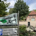 Lintler Krug Der Lintler Krug ist ein traditionelles Backsteingebäude mit begrüntem Vorplatz und großem Baum.